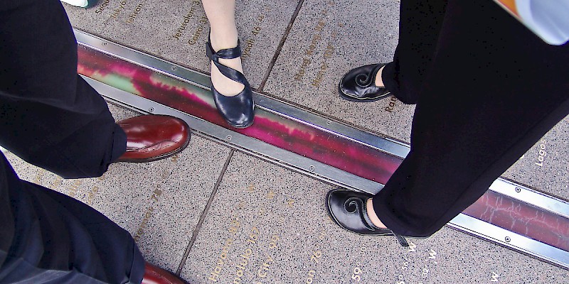 The popular tradition of standing in two hemispheres along the official Prime Meridian (Longitude 0Âº) at the Royal Observatory in Greenwich (Photo Â© Reid Bramblett)